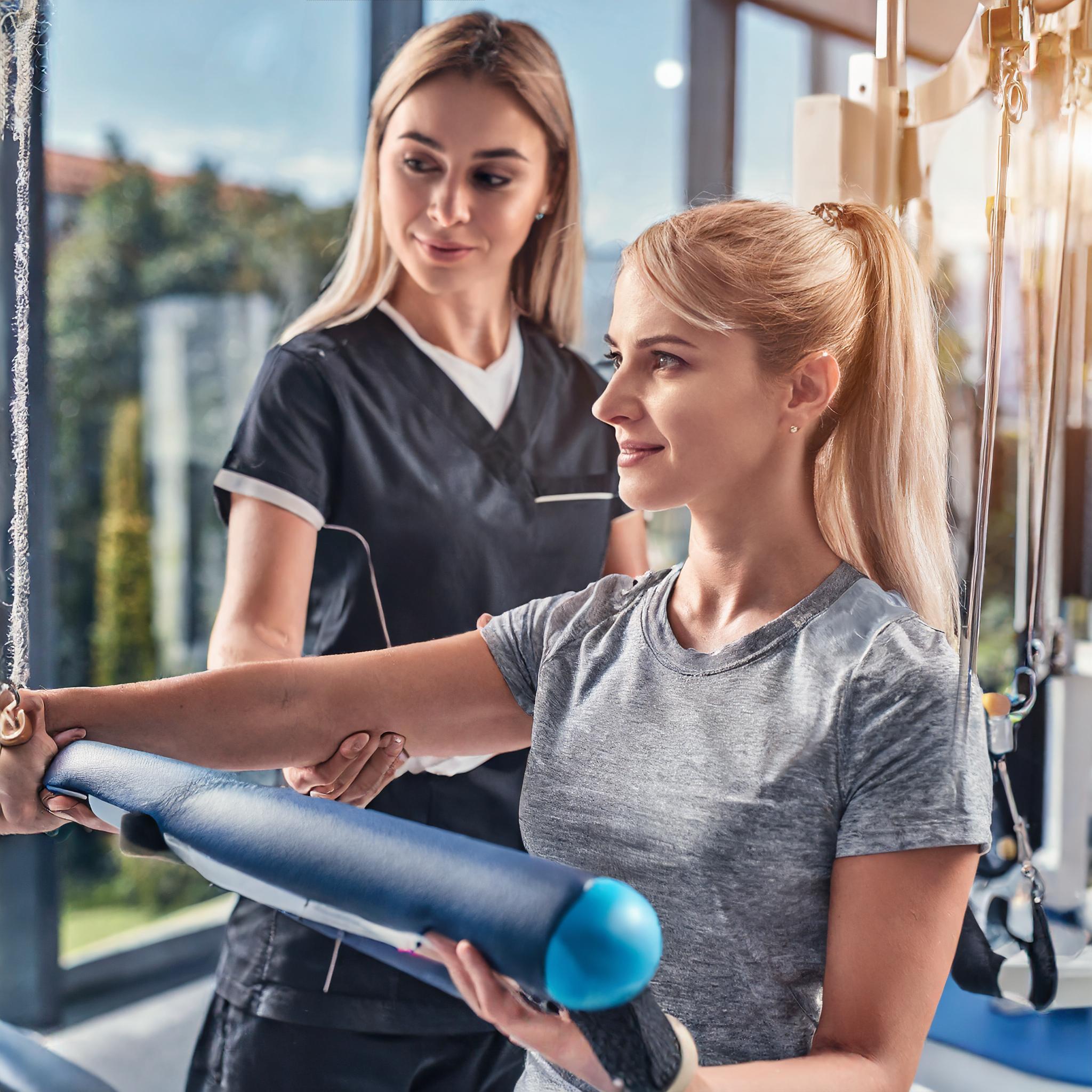 Trainer, der individuelle Pilatesübungen anleitet
